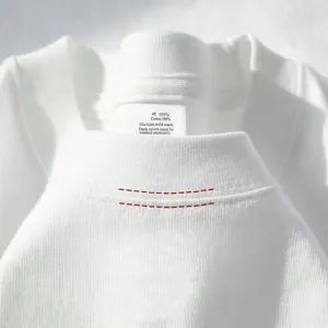 White t-shirt collar detail close-up showcasing neat stitching and soft cotton fabric texture.