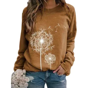 Detailopname van de paardenbloemprint en zachte stof op de casual bruine sweater.