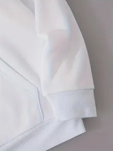 Detailopname van de witte hoodie mouw en geribde manchet met hoogwaardige textuur.