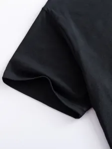 Black t-shirt sleeve fabric detail close-up view showing clean stitching and smooth texture.