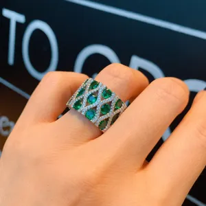 Anillo retro plateado ancho con gemas ovales verdes vibrantes y cristales brillantes pavimentados.
