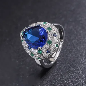 Vintage pear-shaped blue synthetic tanzanite ring with colorful cubic zirconia halo for women.