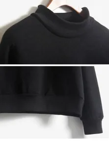Detailopname van zwart sweater met opstaande kraag en duidelijke geribbelde manchetten.