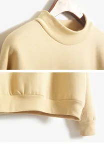 Gedetailleerd overzicht van de gele coltrui, met fijne geribbelde textuur bij kraag en zoom.
