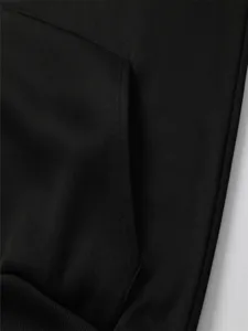Detailopname van de zwarte hoodie zak en hoogwaardige katoenen stof textuur, minimalistisch design.
