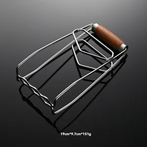 Stainless steel dish gripper detail showing anti-scalding design with secure wooden handle.