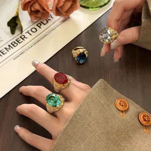 Detailed close-up of vintage gold-plated oval gemstone rings worn on fingers with props.