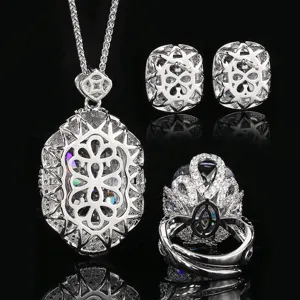 Detail de parure de bijoux argent vintage exquis avec pendentif ajouré, boucles d'oreilles, bague.