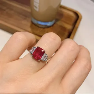 Anello di stile europeo con rubino sintetico rettangolare e pietre laterali indossato a mano vista