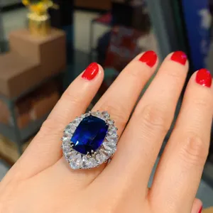 Magnifico anello in tanzanite simulata con grande pietra blu a cuscino e alone luminoso.