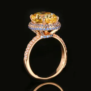 Elegante anello di lusso con gemma gialla 10x12mm, alone blu e fascia in oro rosa.