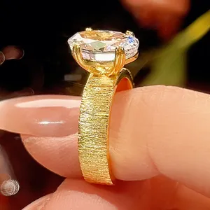 Elegante anillo chapado en oro con banda cepillada y gema brillante para mujer.