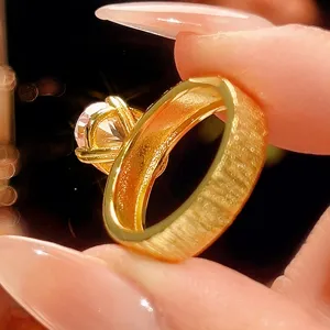 Detalle de anillo dorado cepillado que muestra la banda texturizada y gema de color.