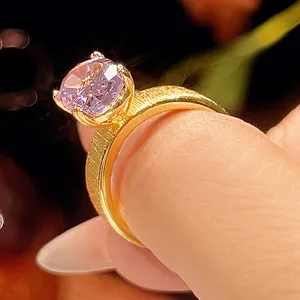 Vista detallada en primer plano del anillo chapado en oro con piedra rosa y banda cepillada.