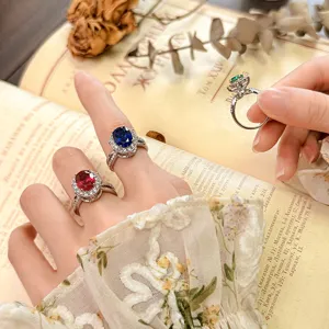 Primer plano detallado de elegantes anillos de piedra ovalada con halo de circonita.