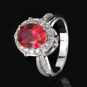 Elegante anillo de plata con gema ovalada roja y brillante diseño de halo de cristales.