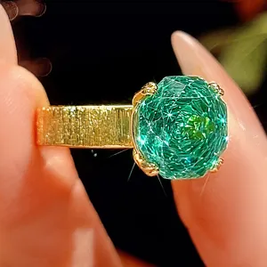 Vista dettagliata anello donna 12mm oro spazzolato con gemma verde taglio millennio.