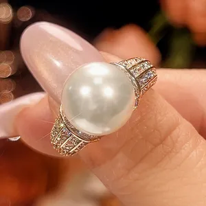 Anello vintage con perla da 12mm, elegante design placcato rame e pietre scintillanti.