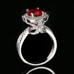 Detalle de primer plano del elegante anillo de corindón rojo ovalado con halo de micropavé.