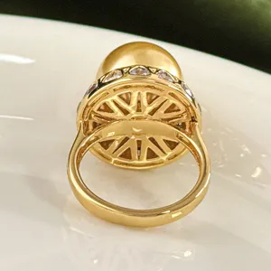Close-up detailweergave van de prachtige opengewerkte ringmand met grote parel.