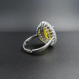 Vista detallada del anillo de plata ajustable con piedra amarilla ovalada y pavé.