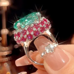 Bague cocktail luxueuse à grand gemme vert avec pavé de rubis roses et diamants scintillants.