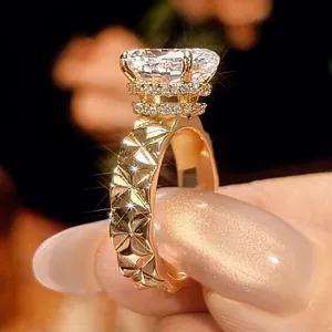 Anello geometrico trapuntato placcato in oro con grande gemma sintetica e alone pavé.
