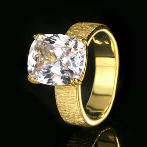 Gros plan detaille de la bague doree avec oxyde de zirconium taille coussin et texture brossee.