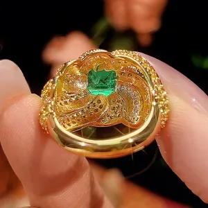 Primo piano dettagliato dell'anello chiuso placcato in oro con una pietra verde quadrata.