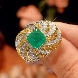 Primo piano dettagliato del lussuoso anello con pietra verde quadrata e pavé di cristalli.
