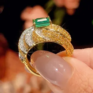 Splendido anello cocktail con smeraldo simulato e pietre gialle e bianche placcate oro.