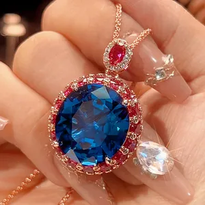 Nahaufnahme Detail eines luxuriösen ovalen blauen Stein Anhängers mit rotem Stein Halo in Roségold.