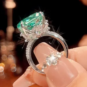 Detailed view of the luxury millennium cut paraiba green gemstone ring with paved band.