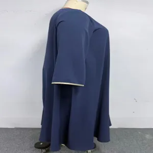 Vue de profil détaillée du cardigan ample bleu foncé à manches longues avec bordure dorée.