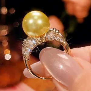 Primo piano dettagliato dell'anello con perla dorata e pietre scintillanti ed eleganti.