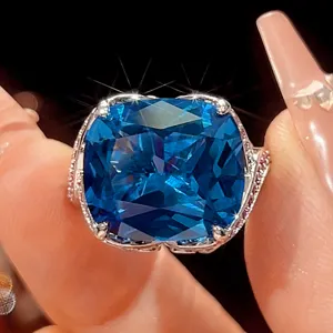 Close-up detail of cushion cut blue gemstone ring with vintage claw setting and side sparkle.