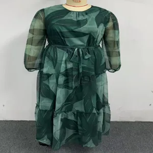 Grünes Chiffonkleid Detail mit Blätterdruck, rundem Ausschnitt und langen Ärmeln.