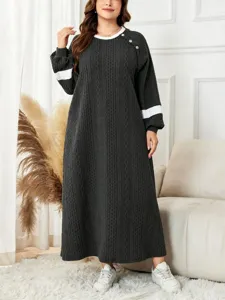 Detailed view of the cozy long-sleeve knit dress featuring contrasting details and shoulder buttons.