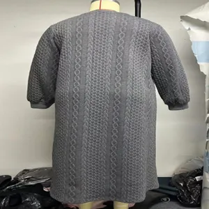 Detailansicht des grauen Oversize Zopfmuster Langstrickkleids, gemuetlicher Winterstil.