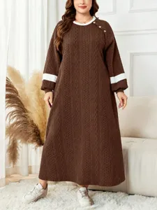 Detail view of the contrast color crew neck knit maxi dress, long sleeves and cozy fit.
