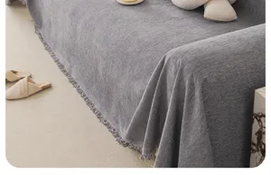 Close-up shot of grey chenille sofa cover texture, showcasing soft fabric and delicate fringe detail.