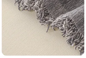 Close-up detail of soft chenille sofa blanket texture with elegant fringes, ideal for home decor.