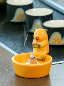 Close-up detail of the cute ceramic incense burner with animal figurine, desktop decor zen.