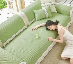 Detail view of the ice silk waffle sofa cover with elegant lace ruffle skirt in green.