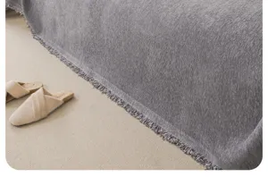 Close-up detail of the gray textured chenille sofa blanket with delicate fringe trim.