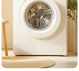 Detailed view of modern minimalist front-load washing machine in warm home interior setting.