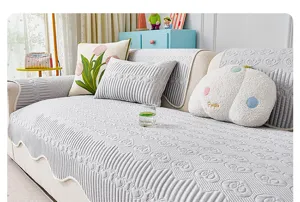 Vista detallada del cojín de sofá de seda de hielo estilo crema con elegantes patrones en relieve.