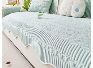 Detalle de cojín de sofá verde claro de seda de hielo con textura acolchada de corazones.
