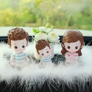 Cute cartoon family car dashboard doll ornament set with white feathers and mini potted flower decor.