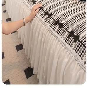 Chenille sofa cover detail showcasing elegant black bows and white lace pleated skirt trim.